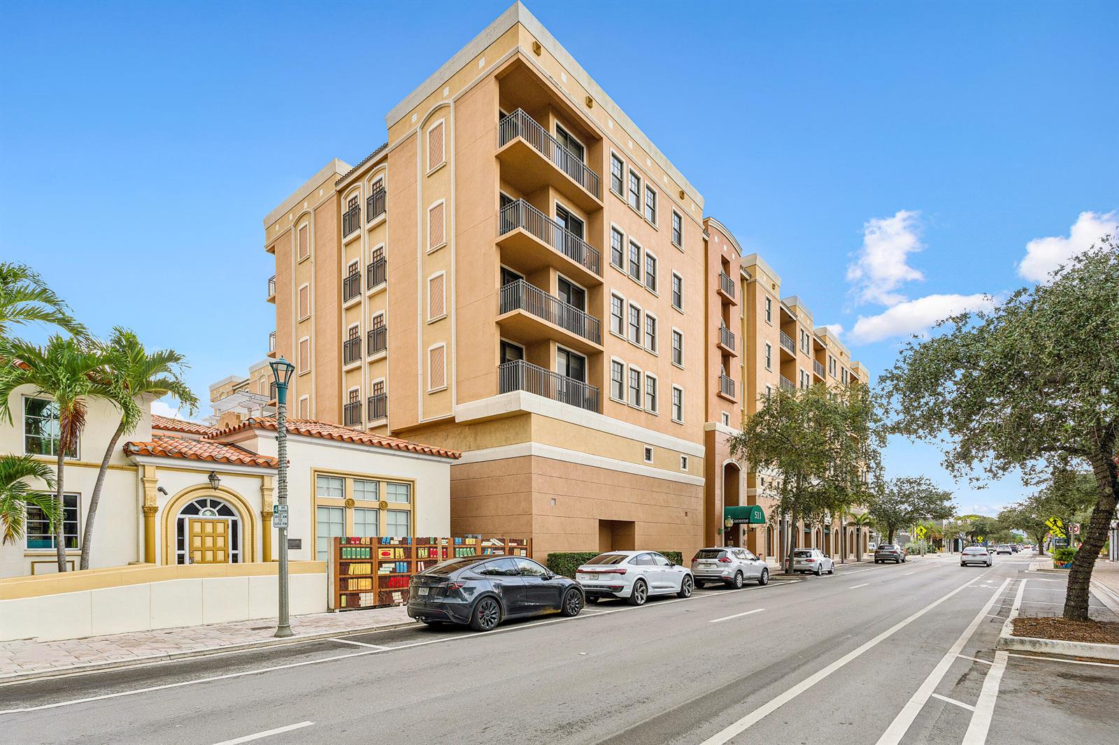 A multi-story tan apartment building stands along a street with parked cars and palm trees — 511 Lucerne Avenue # 416, FL 33460, FL