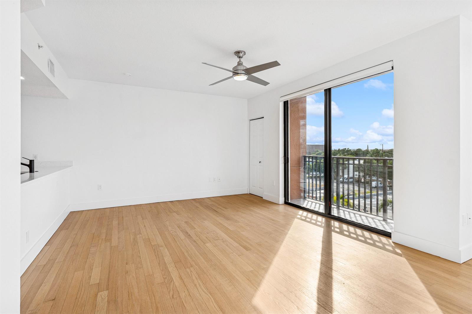 An empty room with light wood floors, a ceiling fan, and a balcony with railings — 511 Lucerne Avenue # 416, FL 33460, FL