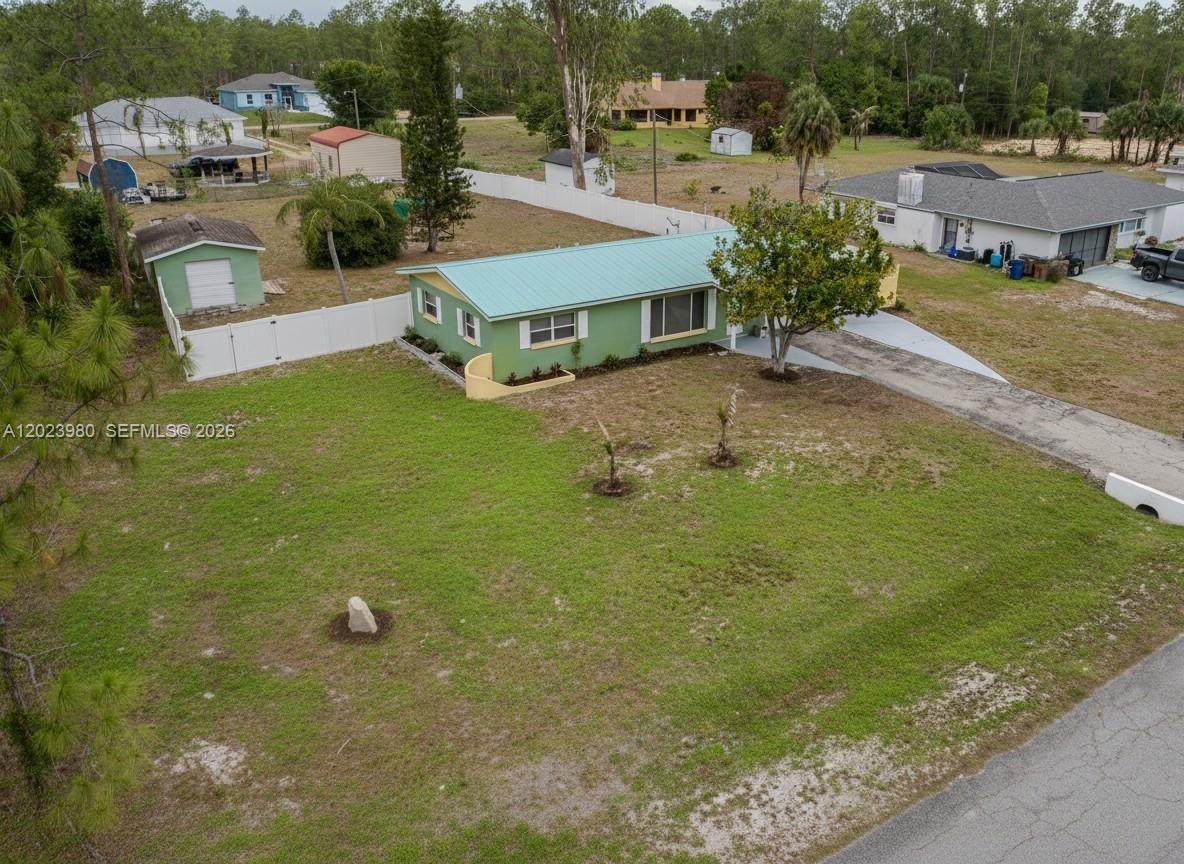 An aerial view shows a green house with a metal roof and a large yard — 1313 E CLEVELAND AVE, Lehigh Acres FL 33972, LEHIGH ACRES, FL