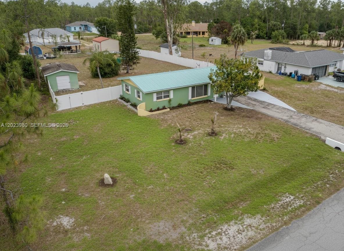 An aerial view shows a green house with a metal roof and a large yard — 1313 E CLEVELAND AVE, Lehigh Acres FL 33972, LEHIGH ACRES, FL