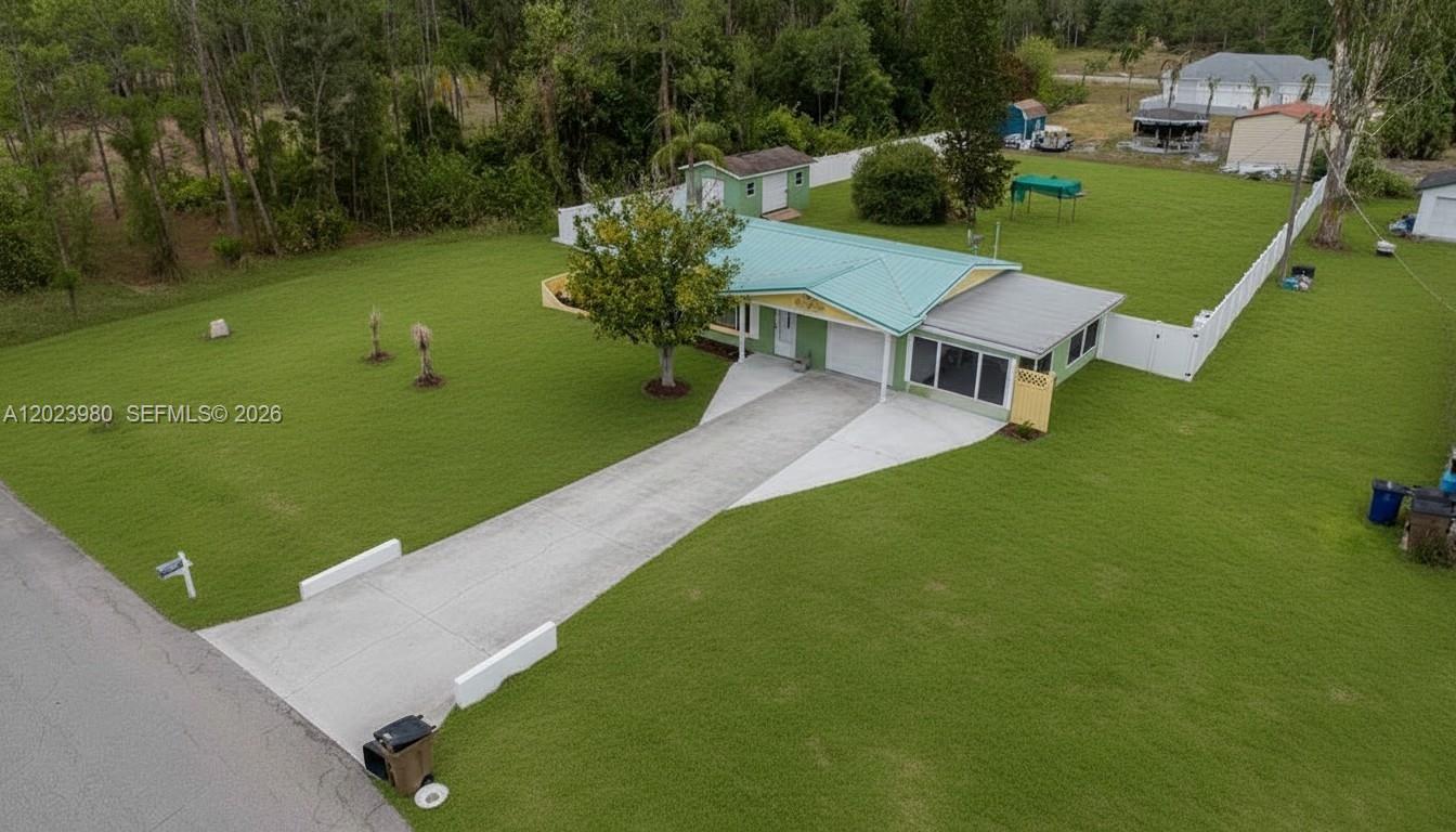 An aerial view shows a single-story house with a green metal roof and large yard — 1313 E CLEVELAND AVE, Lehigh Acres FL 33972, LEHIGH ACRES, FL