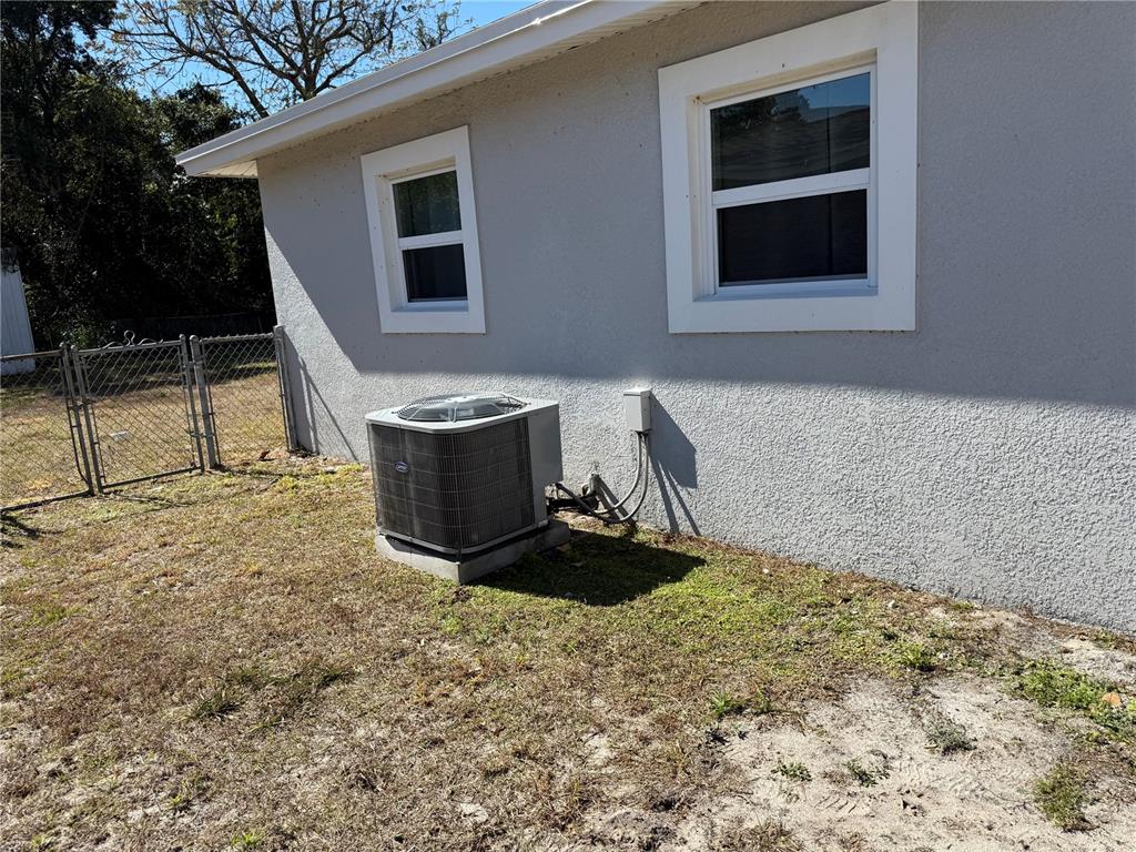 An exterior view of a house wall with two windows and an air conditioning unit — 204 6TH JPV STREET, WINTER HAVEN, FL