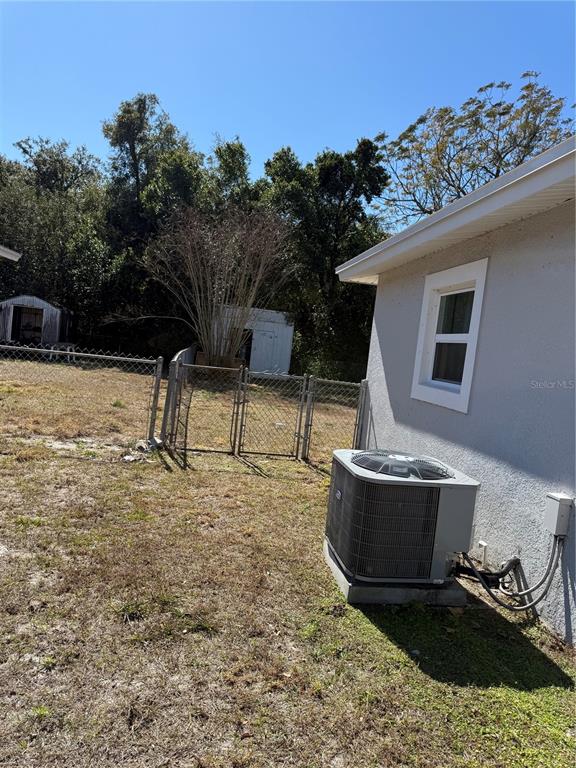 A side view of a house exterior showing an air conditioning unit and a fenced yard — 204 6TH JPV STREET, WINTER HAVEN, FL