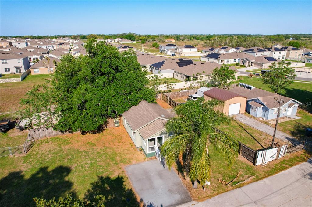 An aerial view shows a small house with a large tree and detached garage — 213 CLEVELAND AVENUE, WINTER HAVEN, FL