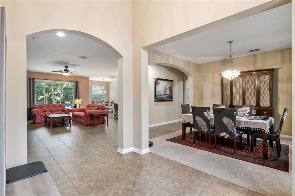 A view from a tiled entryway into a living room and a formal dining room — 2028 MISTY GLEN DRIVE, APOPKA, FL