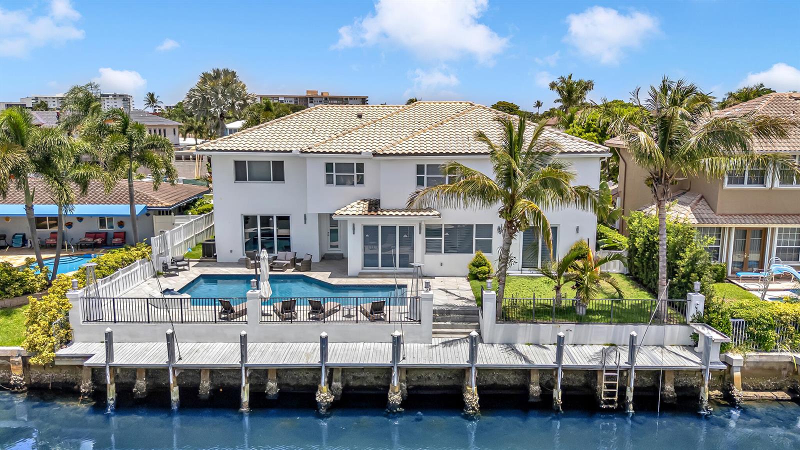 An aerial view of a two-story white house with a pool and a wooden dock — 4921 NE 28TH Avenue, Lighthouse Point FL 33064, LIGHTHOUSE POINT, FL