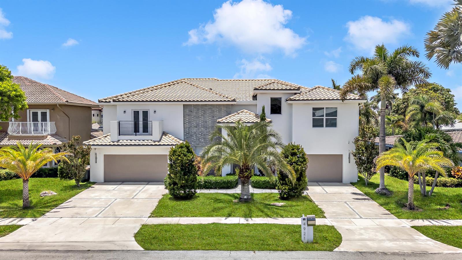 A two-story house with a tile roof, two garages, and palm trees in the front yard — 4921 NE 28TH Avenue, Lighthouse Point FL 33064, LIGHTHOUSE POINT, FL