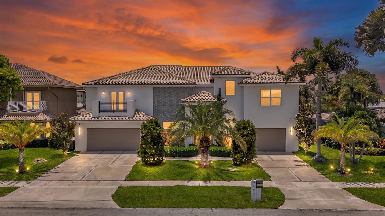 A two-story house with a tile roof, two garages, and palm trees at sunset — 4921 NE 28TH Avenue, Lighthouse Point FL 33064, LIGHTHOUSE POINT, FL