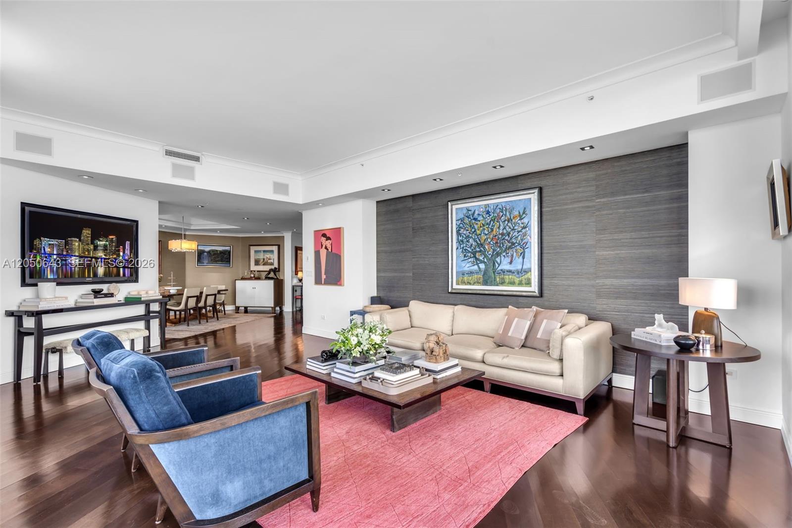 A living room features a dark accent wall, a beige sofa, and two blue armchairs — 848 Brickell Key Drive, Miami FL 33131, MIAMI, FL