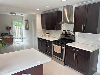 A modern kitchen features dark wood cabinets, white countertops, stainless steel appliances, and tile flooring — 12500 SW 104th Ter, Miami FL 33186, MIAMI, FL