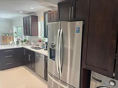 A kitchen features dark wood cabinets, stainless steel appliances, and light-colored countertops — 12500 SW 104th Ter, Miami FL 33186, MIAMI, FL