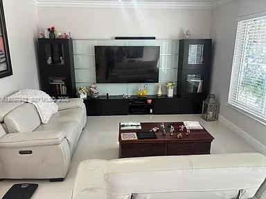 A living room features a white sofa, a dark wood coffee table, and a media wall — 12500 SW 104th Ter, Miami FL 33186, MIAMI, FL