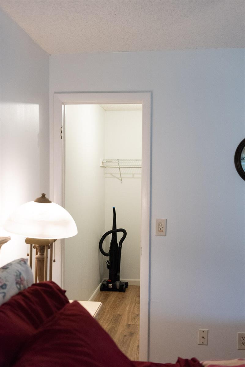 A bedroom closet with a wire shelf and a vacuum cleaner on wood-look flooring — 416 Capri I, Delray Beach FL 33484, DELRAY BEACH, FL