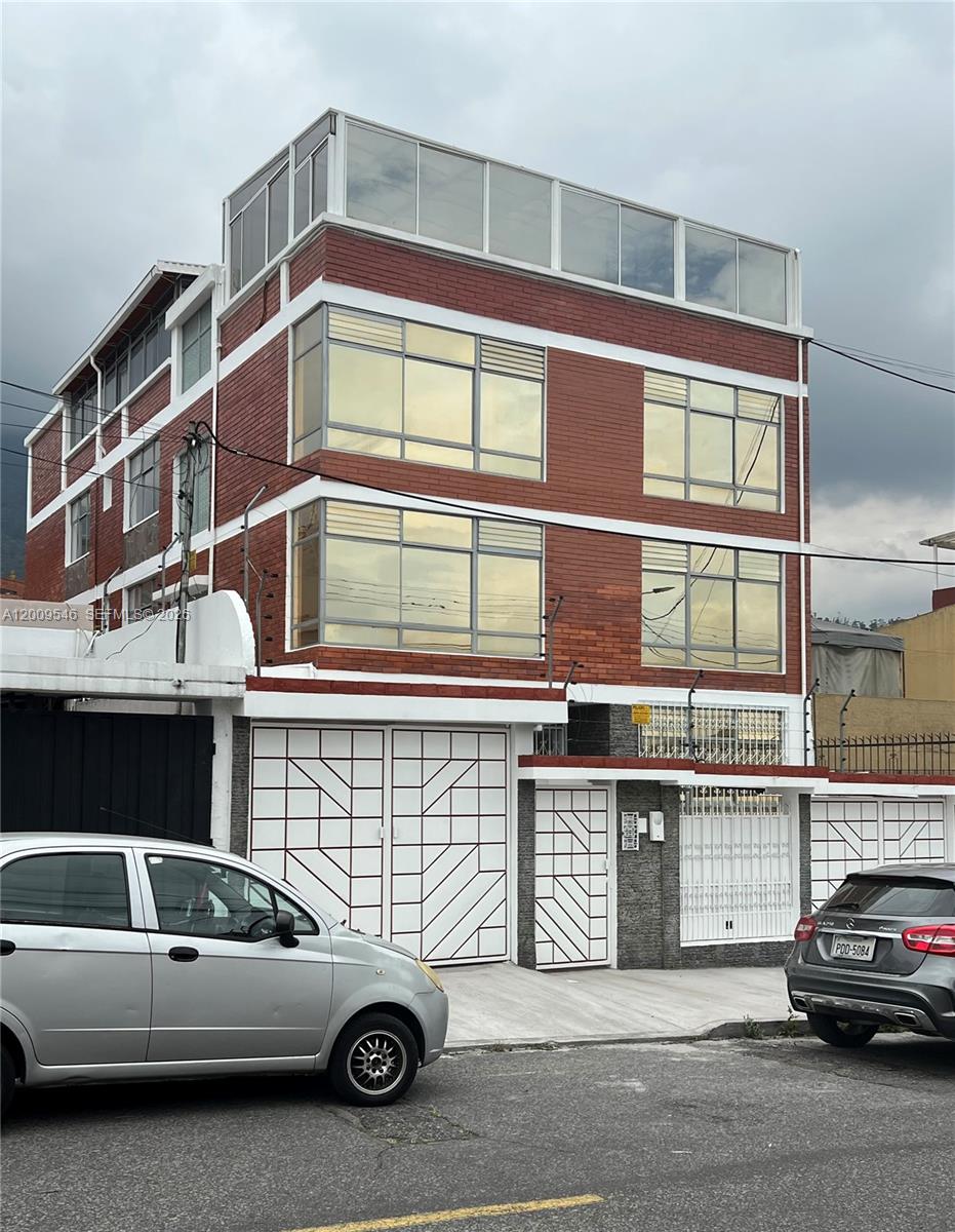 A three-story brick building with large windows and a glass-enclosed top floor — N35-95 Calle Manuela Sáenz, FL, FL