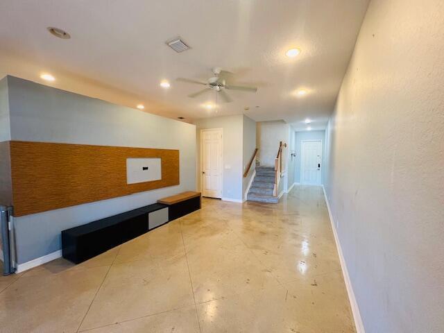 A living room features a wood-paneled accent wall, a black media console, and concrete floors — 30 Beechdale Lane, Boynton Beach FL 33426, BOYNTON BEACH, FL