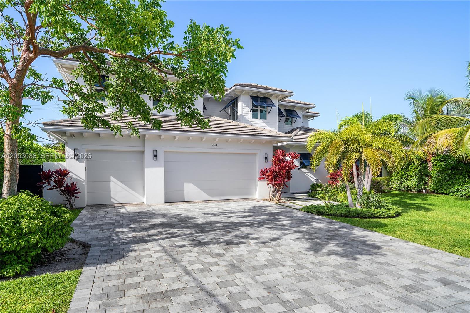 A two-story white house features a paved driveway, a three-car garage, and tropical landscaping — 728 Malaga Dr, Boca Raton FL 33432, BOCA RATON, FL
