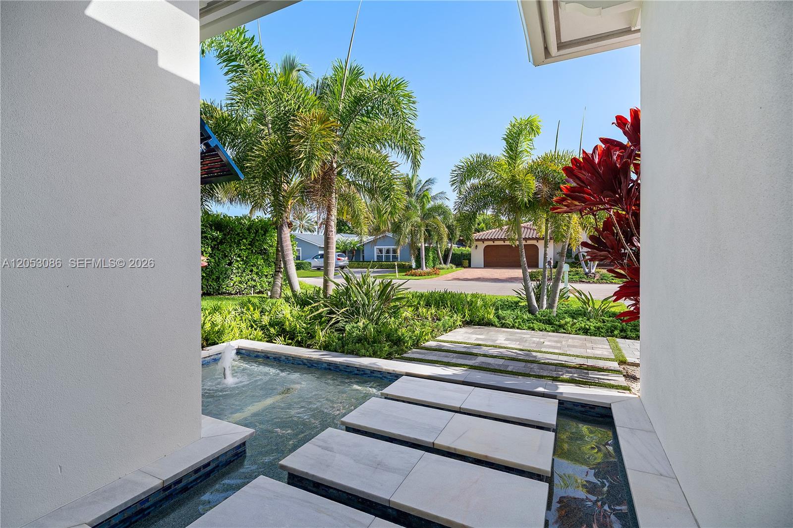 A stone walkway crosses a water feature leading to an outdoor residential entrance — 728 Malaga Dr, Boca Raton FL 33432, BOCA RATON, FL