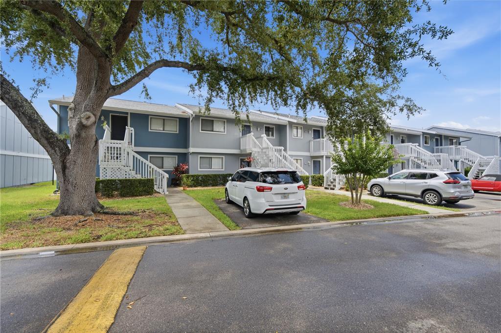 A two-story apartment building with white stairs and a parking lot in front — 6033 34TH STREET W UNIT 44, BRADENTON, FL