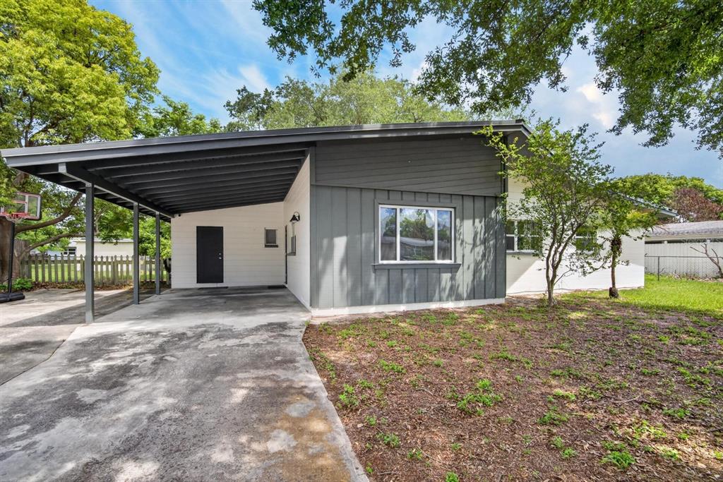 A single-story house with a carport, gray vertical siding, and white horizontal siding — 113 6TH JPV STREET, WINTER HAVEN, FL