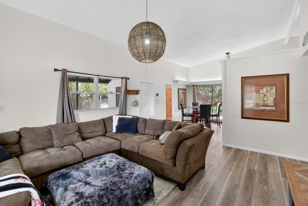 A living room features a large brown sectional, a patterned ottoman, and a woven pendant light — 113 6TH JPV STREET, WINTER HAVEN, FL