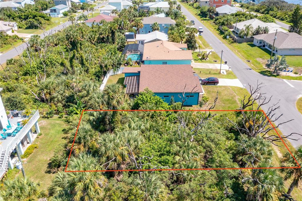 An aerial view shows a vacant, wooded residential lot outlined in red next to existing houses — 31 ROLLINS DRIVE, PALM COAST, FL