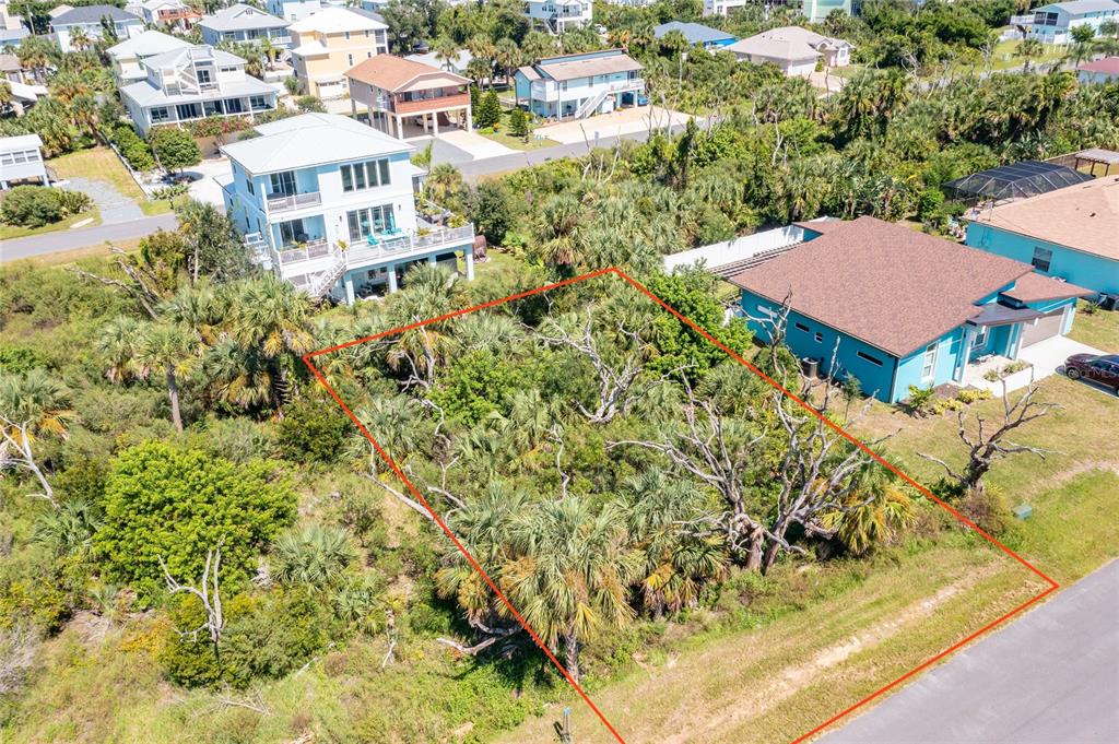 An aerial view shows a vacant, wooded residential lot outlined in red next to houses — 31 ROLLINS DRIVE, PALM COAST, FL
