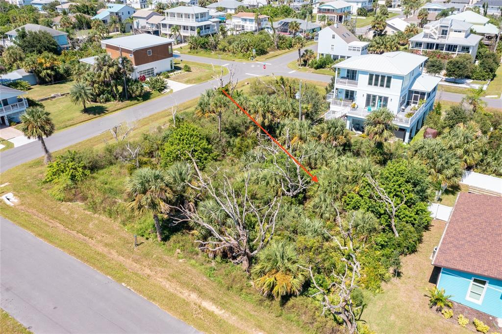 An aerial view shows a vacant, wooded residential lot situated between two paved streets — 31 ROLLINS DRIVE, PALM COAST, FL