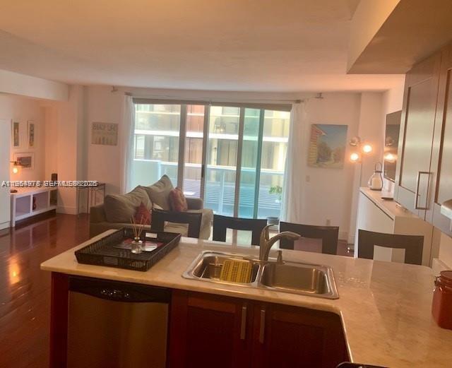 A kitchen island with a stainless steel sink overlooks a living room with a sofa — 9499 Collins Ave # 205, Surfside FL 33154, SURFSIDE, FL