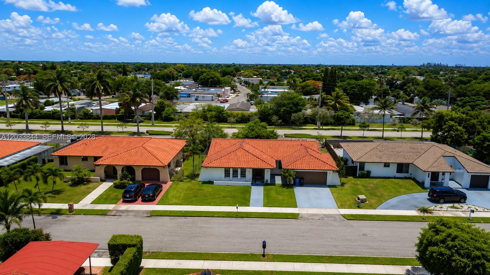An aerial view shows three suburban houses with tiled roofs and front lawns along a street — 1330 SW 126th Pl, Miami FL 33184, MIAMI, FL