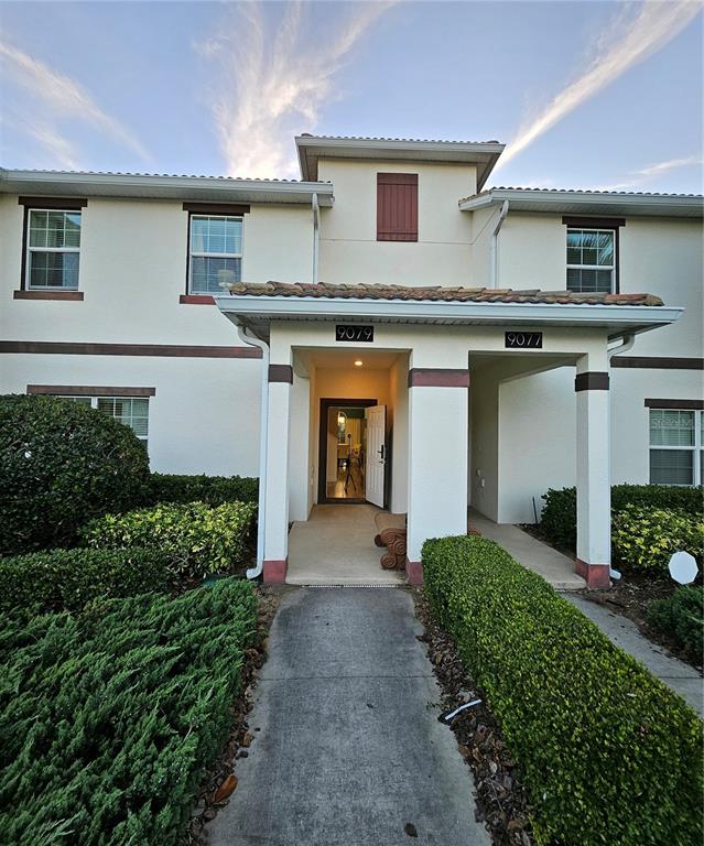 The exterior of a two-story residential building features a covered entryway with two unit numbers — 9079 DOGLEG DRIVE, DAVENPORT, FL