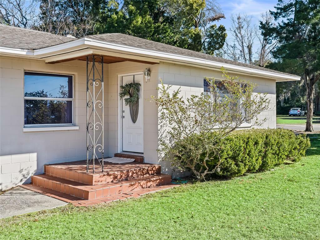 A single-story house with a concrete block exterior, a tiled front porch, and metal columns — 519 HUEY STREET, WILDWOOD, FL