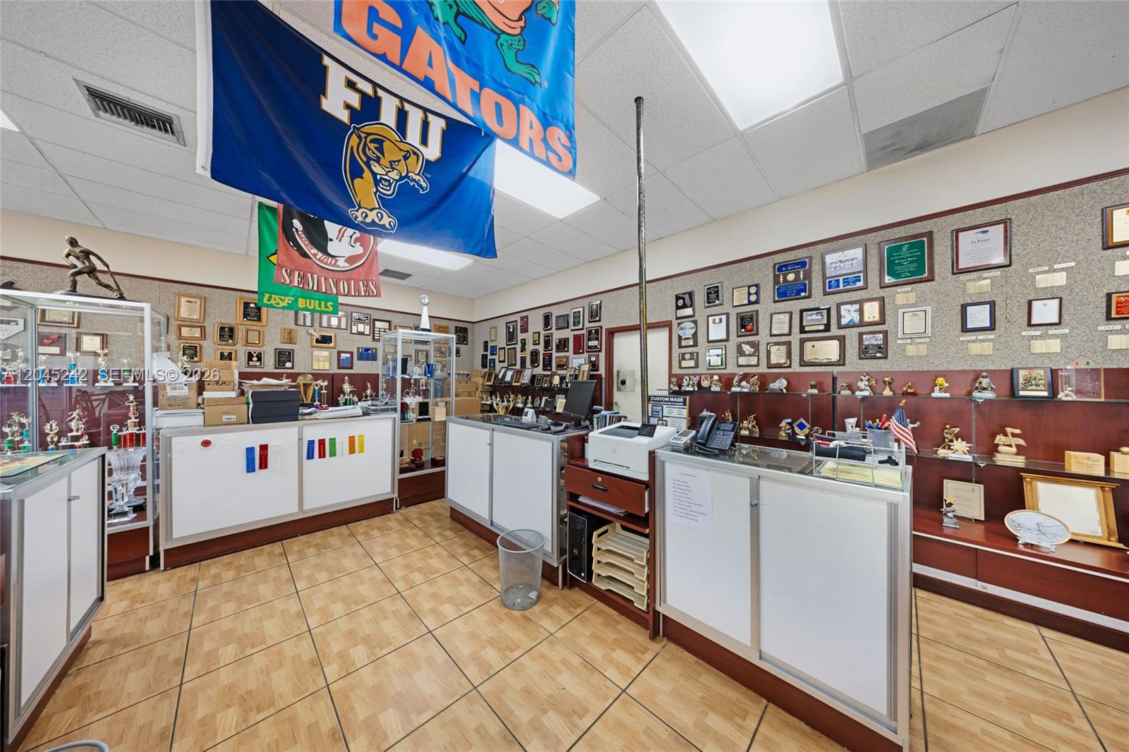 This retail space features trophy display cases, wall-mounted plaques, and a service counter — 9465 SW 56th St, Miami FL 33165, MIAMI, FL