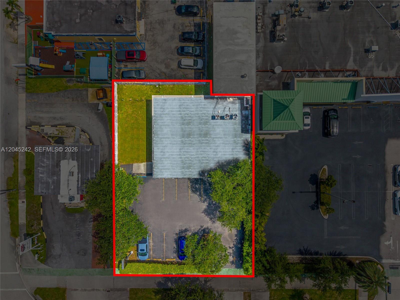 An aerial view shows a commercial building with a parking lot and green space — 9465 SW 56th St, Miami FL 33165, MIAMI, FL