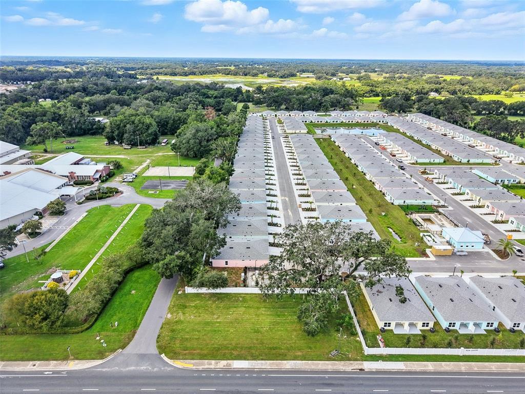 An aerial view shows rows of townhomes with gray roofs and green lawns — 12182 N US HIGHWAY 301, OXFORD, FL