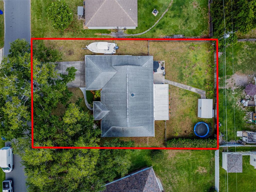 An aerial view shows a house with a gray shingled roof surrounded by green trees — 670 STANHOPE DRIVE, CASSELBERRY, FL