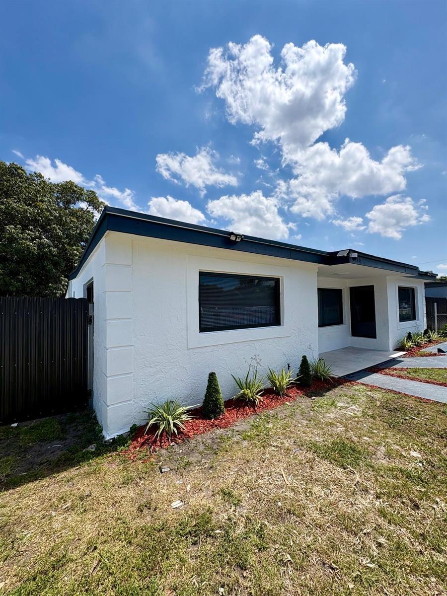 A white, single-story house with a dark roof, black window shutters, and a front yard — 1890 Rutland Street, Opa-Locka FL 33054, OPA-LOCKA, FL