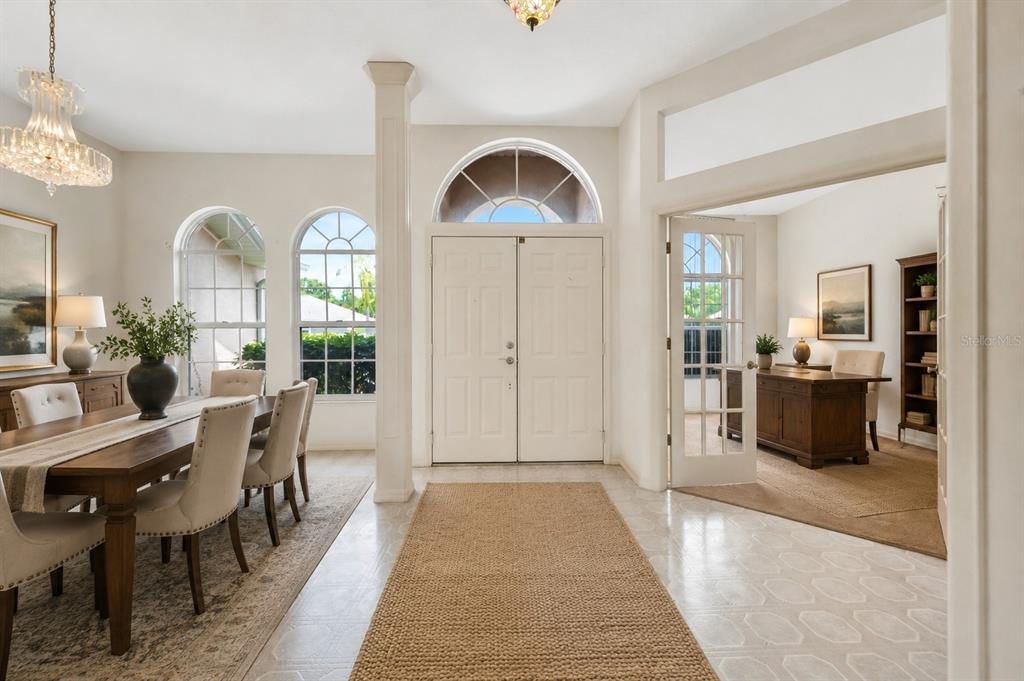 A bright foyer with tile floors leads to a dining room and a home office — 4206 73RD TERRACE E, SARASOTA, FL