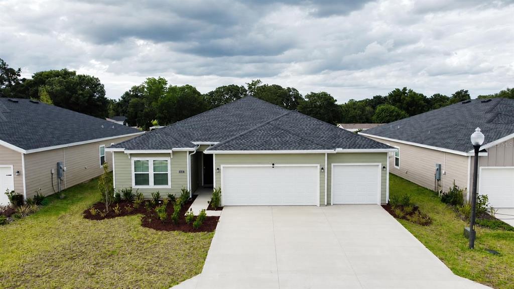 An aerial view of a light green single-story house with a three-car garage — 6583 SW 89TH LOOP, OCALA, FL