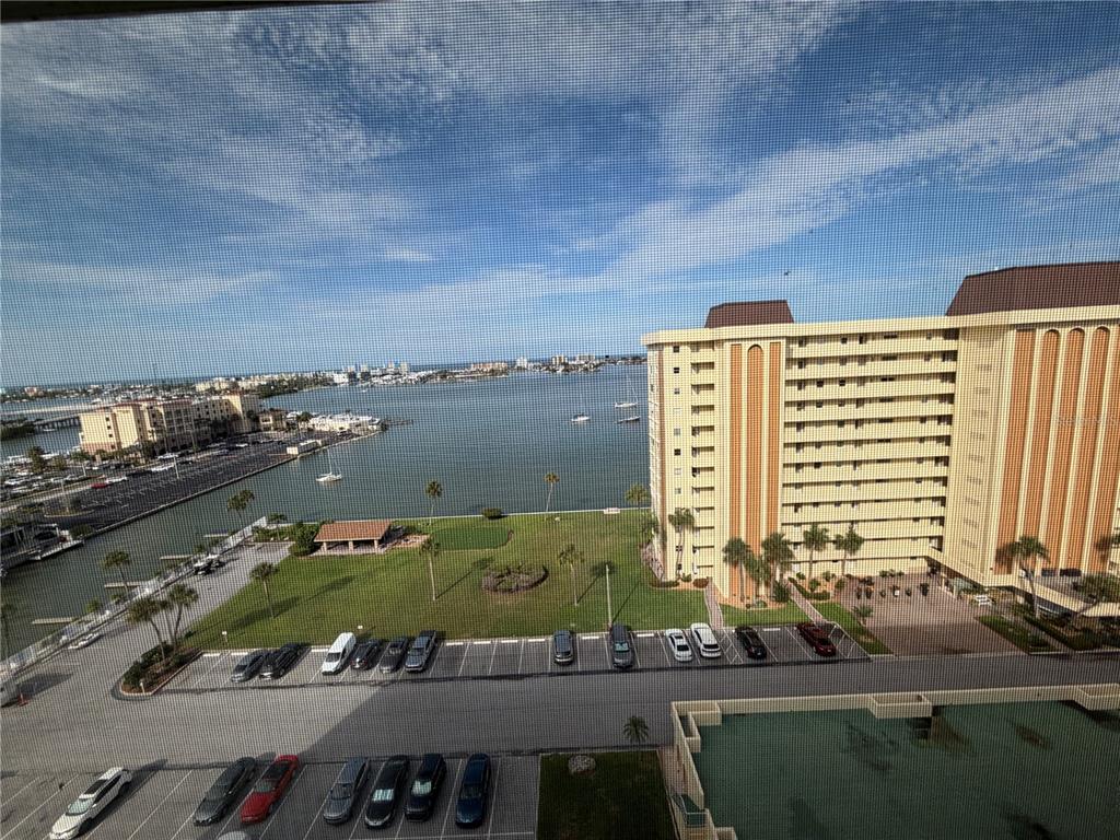 An elevated view shows a parking lot, a grassy lawn, a bay, and a large building — 4550 COVE CIRCLE UNIT 1205, ST PETERSBURG, FL