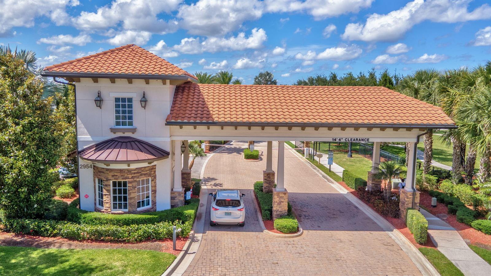 An aerial view shows a gated community entrance with a guardhouse and a white car — 4023 Siena Circle, Wellington FL 33414, WELLINGTON, FL