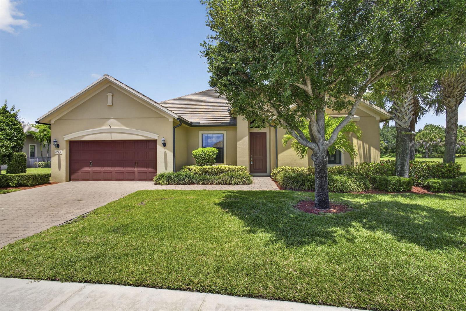 A single-story house with a tan stucco exterior, a brown garage door, and a front lawn — 4023 Siena Circle, Wellington FL 33414, WELLINGTON, FL