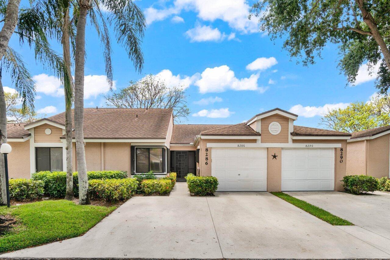 A living and dining area with light wood floors, neutral walls, and a hanging birdcage — 8286 Springlake Drive, Boca Raton FL 33496, BOCA RATON, FL