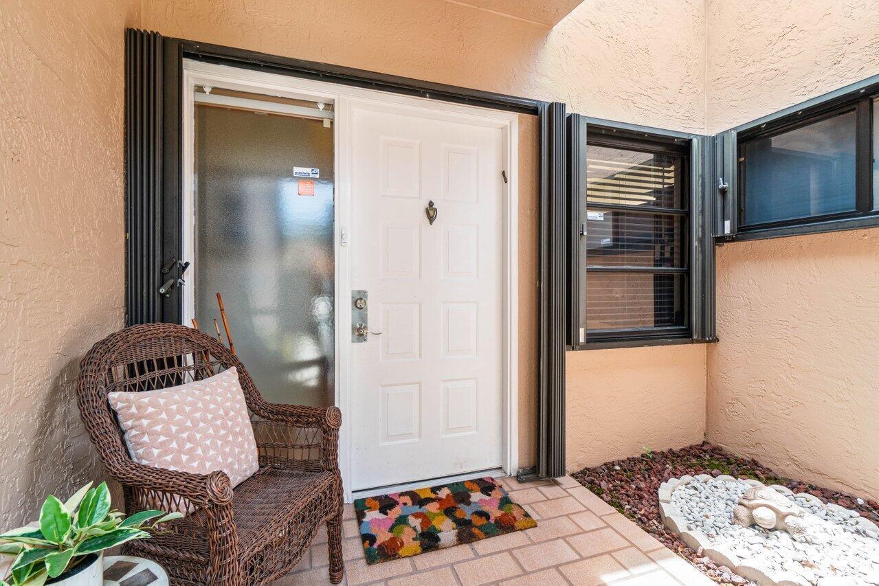 A tan house exterior features a white garage door, a bay window, and a walkway — 8286 Springlake Drive, Boca Raton FL 33496, BOCA RATON, FL