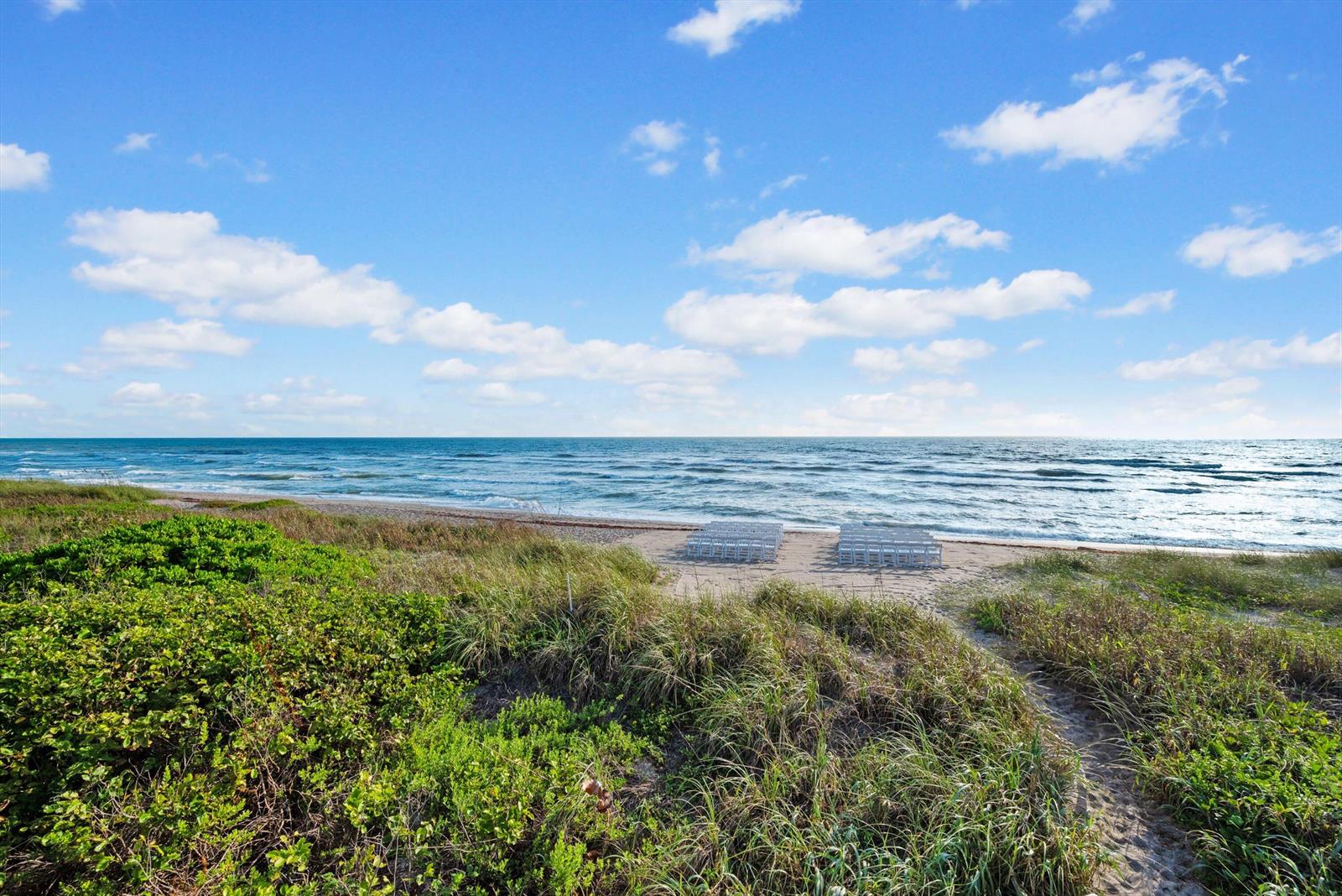 A sandy beach with rows of white chairs overlooking the ocean under a blue sky — 10851 S Ocean Drive, Jensen Beach FL 34957, JENSEN BEACH, FL