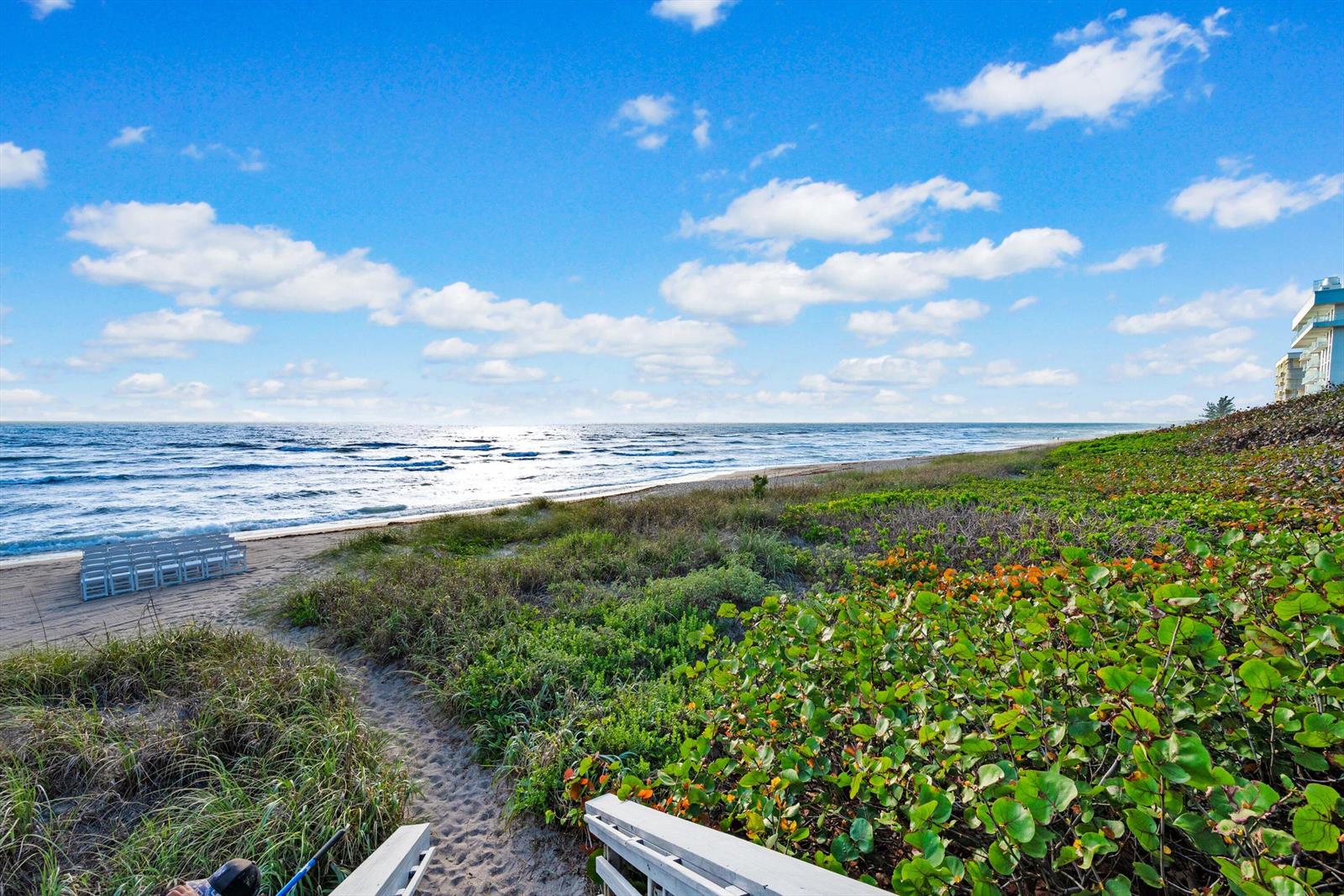 A sandy path leads through coastal vegetation to a beach with ocean waves and chairs — 10851 S Ocean Drive, Jensen Beach FL 34957, JENSEN BEACH, FL