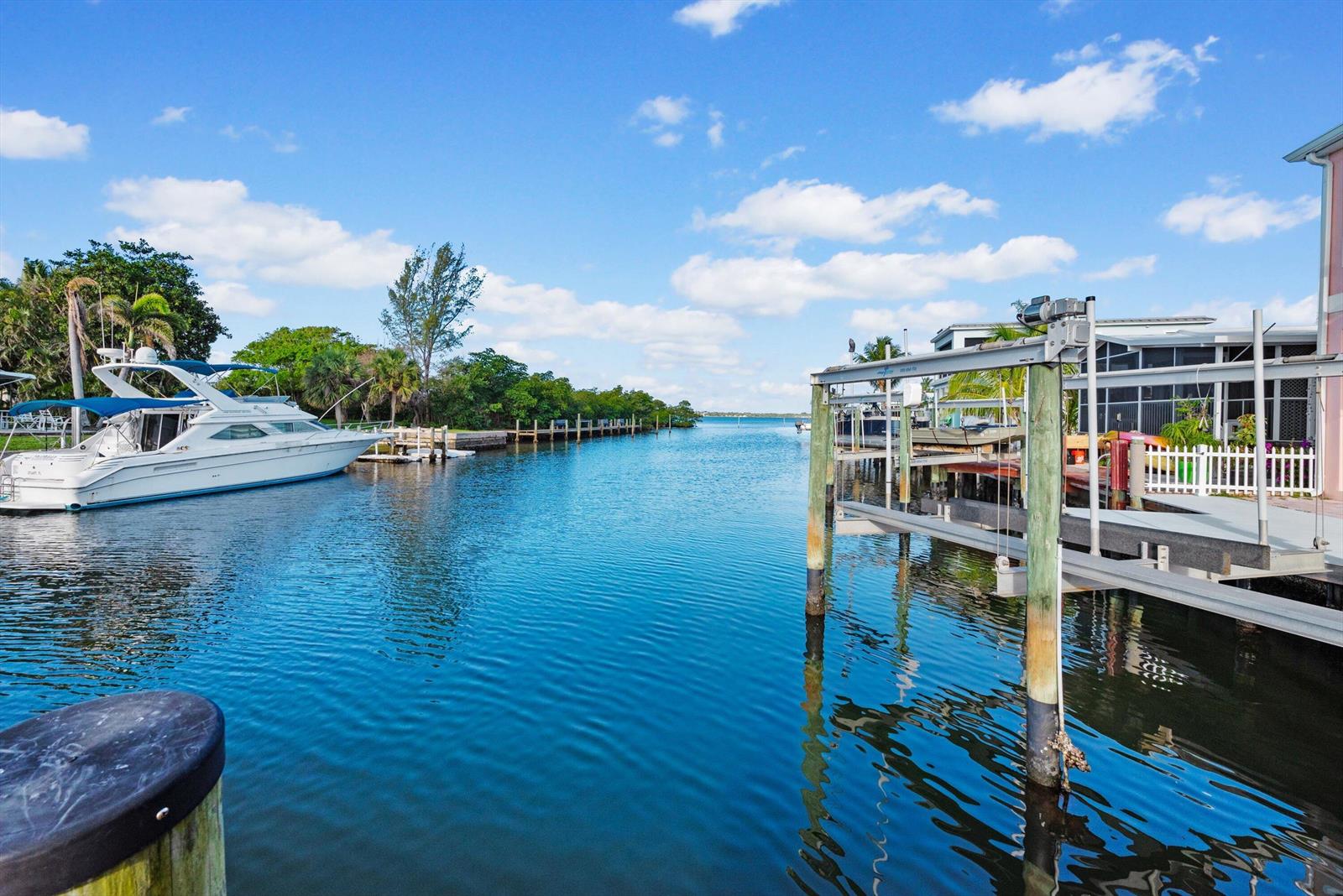 A canal view featuring a boat docked on the left and a boat lift nearby — 10851 S Ocean Drive, Jensen Beach FL 34957, JENSEN BEACH, FL