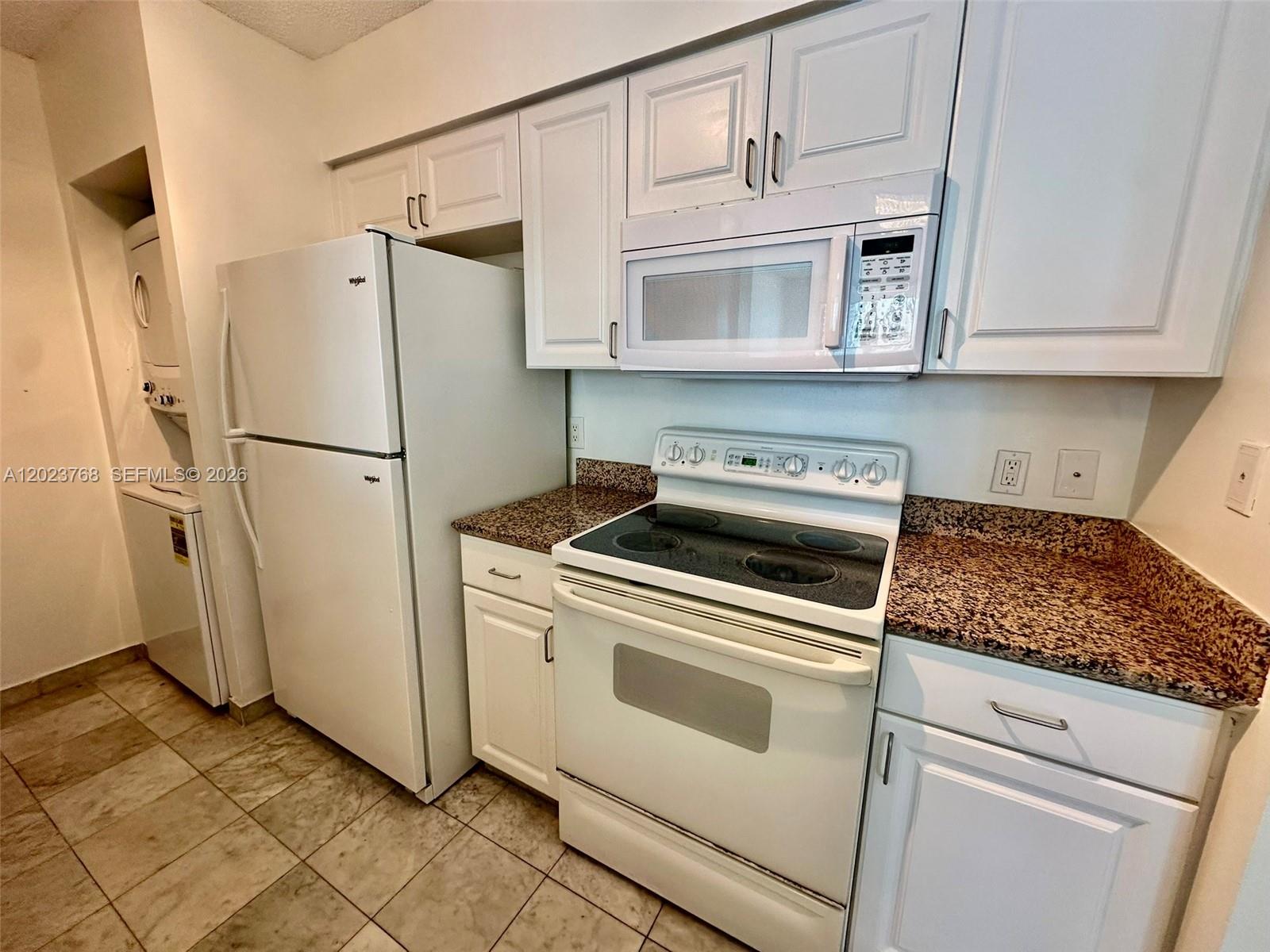 A kitchen features white cabinets, a white refrigerator, an electric stove, and granite countertops — 1155 Brickell Bay Dr # 905, Miami FL 33131, MIAMI, FL