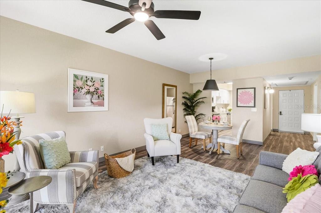A living room and dining area feature wood-look flooring, a ceiling fan, and neutral walls — 4540 BEE RIDGE ROAD UNIT 175, SARASOTA, FL