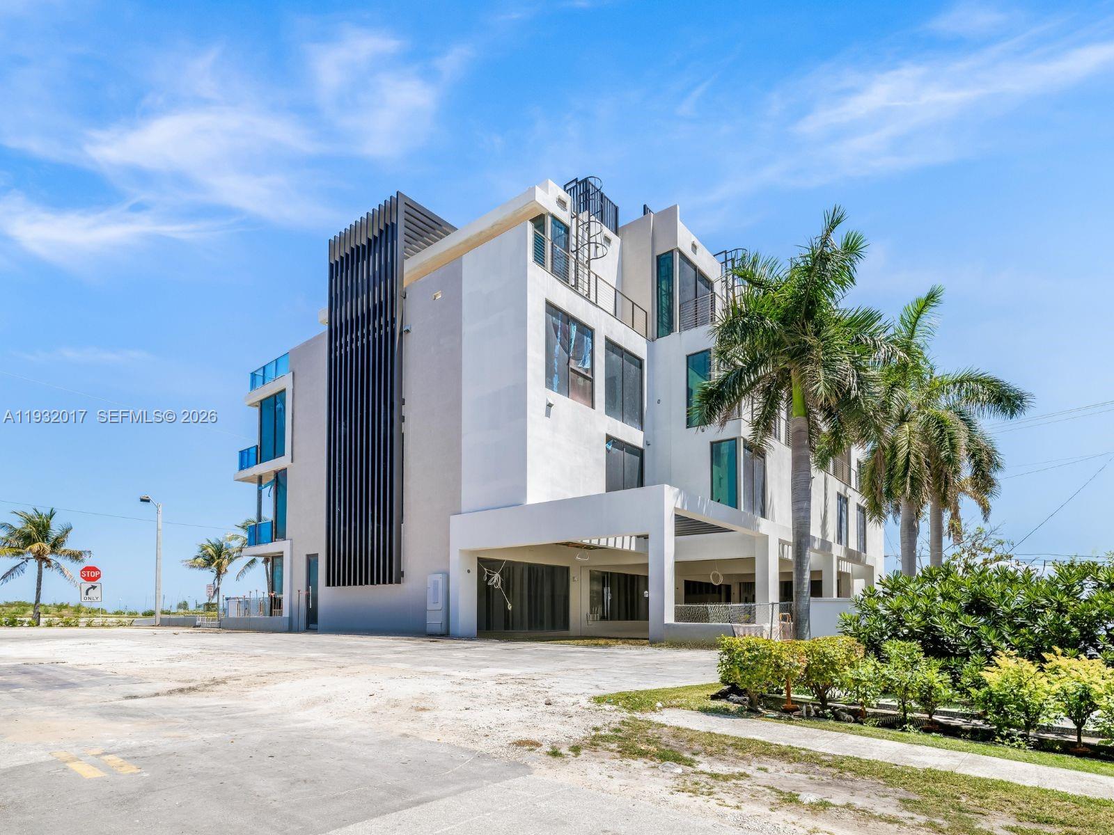 A modern multi-story building with a white exterior, vertical black slats, and palm trees — 493 N Ocean Blvd # 3, Pompano Beach FL 33062, POMPANO BEACH, FL