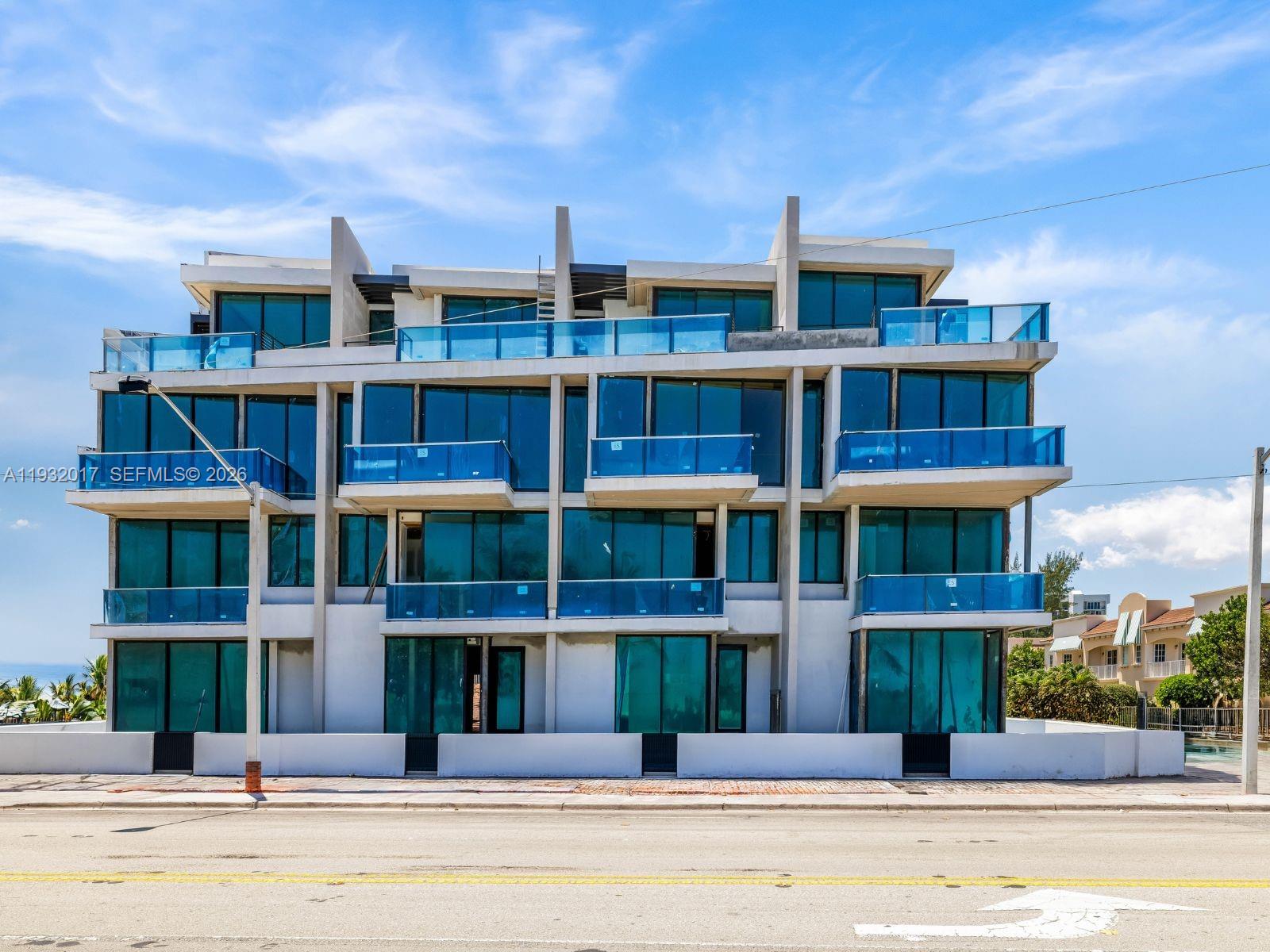 A modern four-story residential building features blue glass balconies and large floor-to-ceiling windows — 493 N Ocean Blvd # 3, Pompano Beach FL 33062, POMPANO BEACH, FL